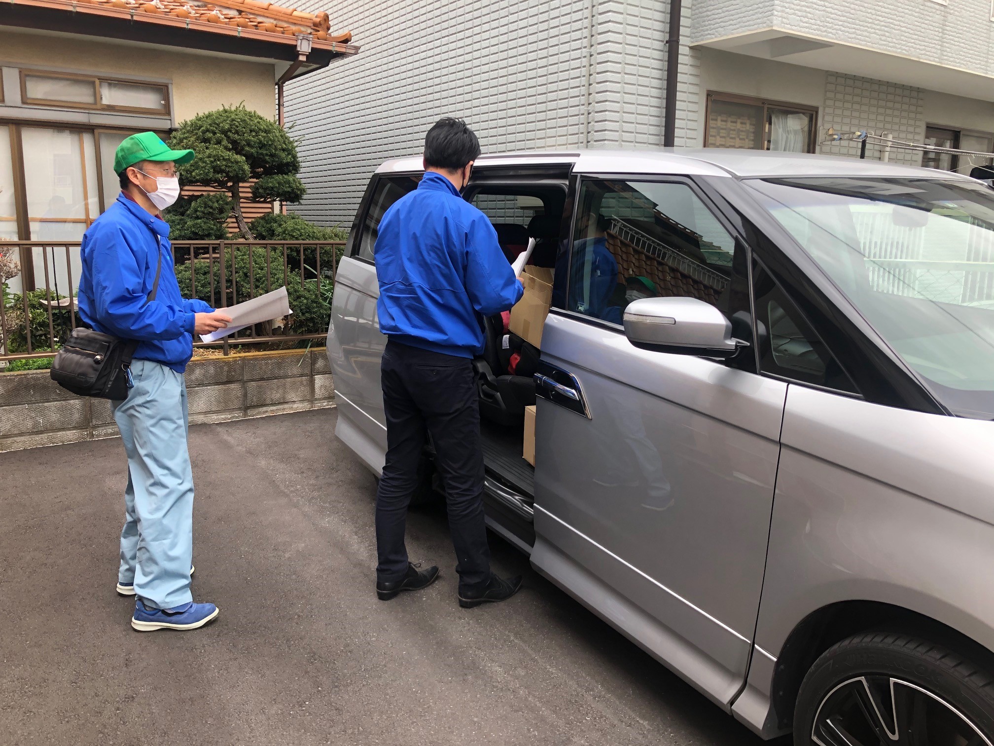 プラッパ―を積んで車に乗り込む男性スタッフ2名
